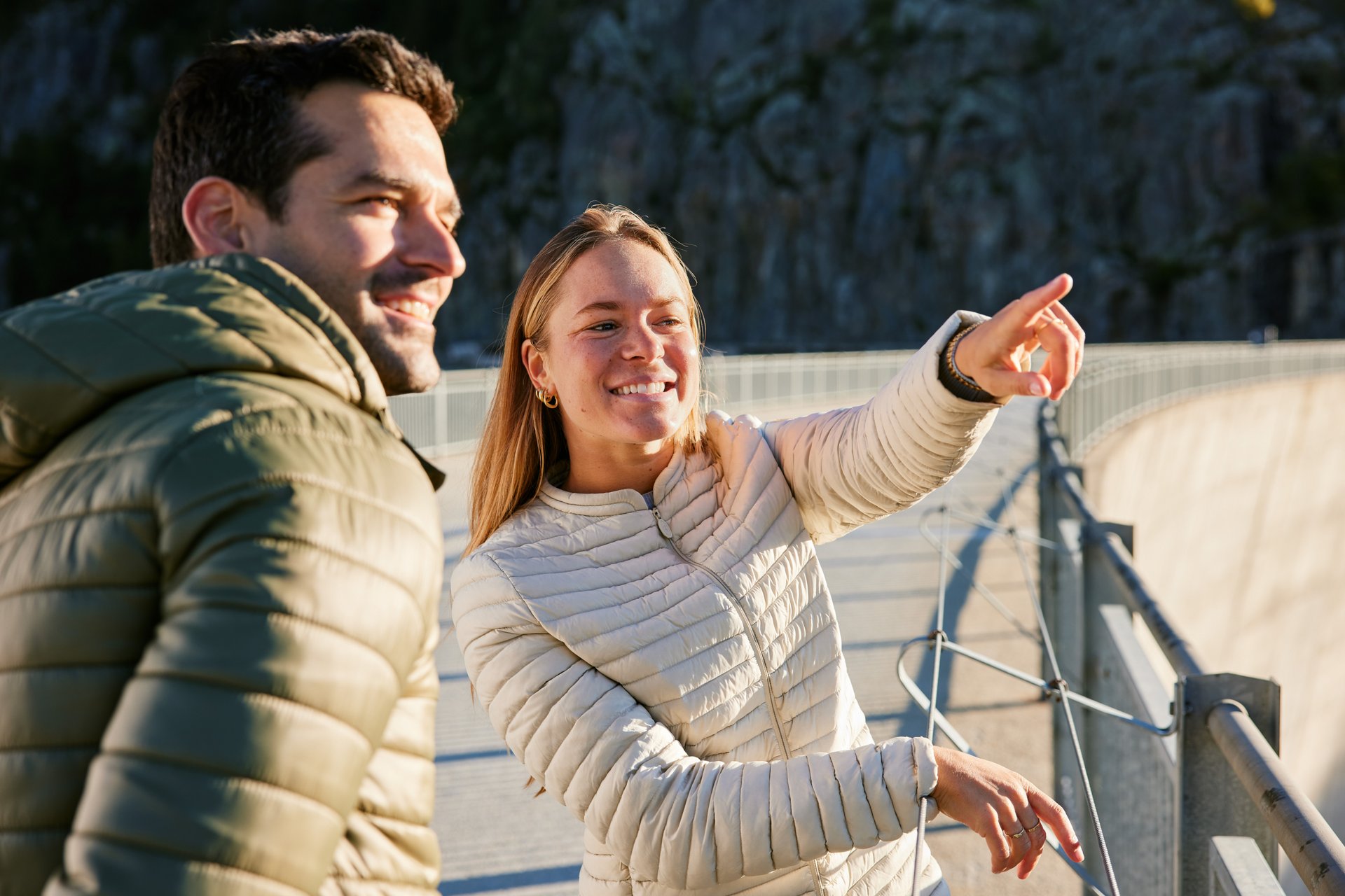 People pointing at something on dam