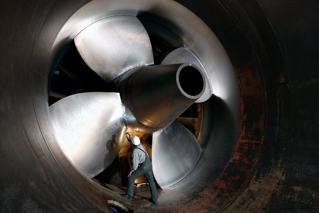 There is a big turbine while a worker is very close to it