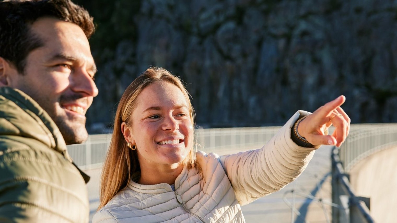 People pointing at something on dam