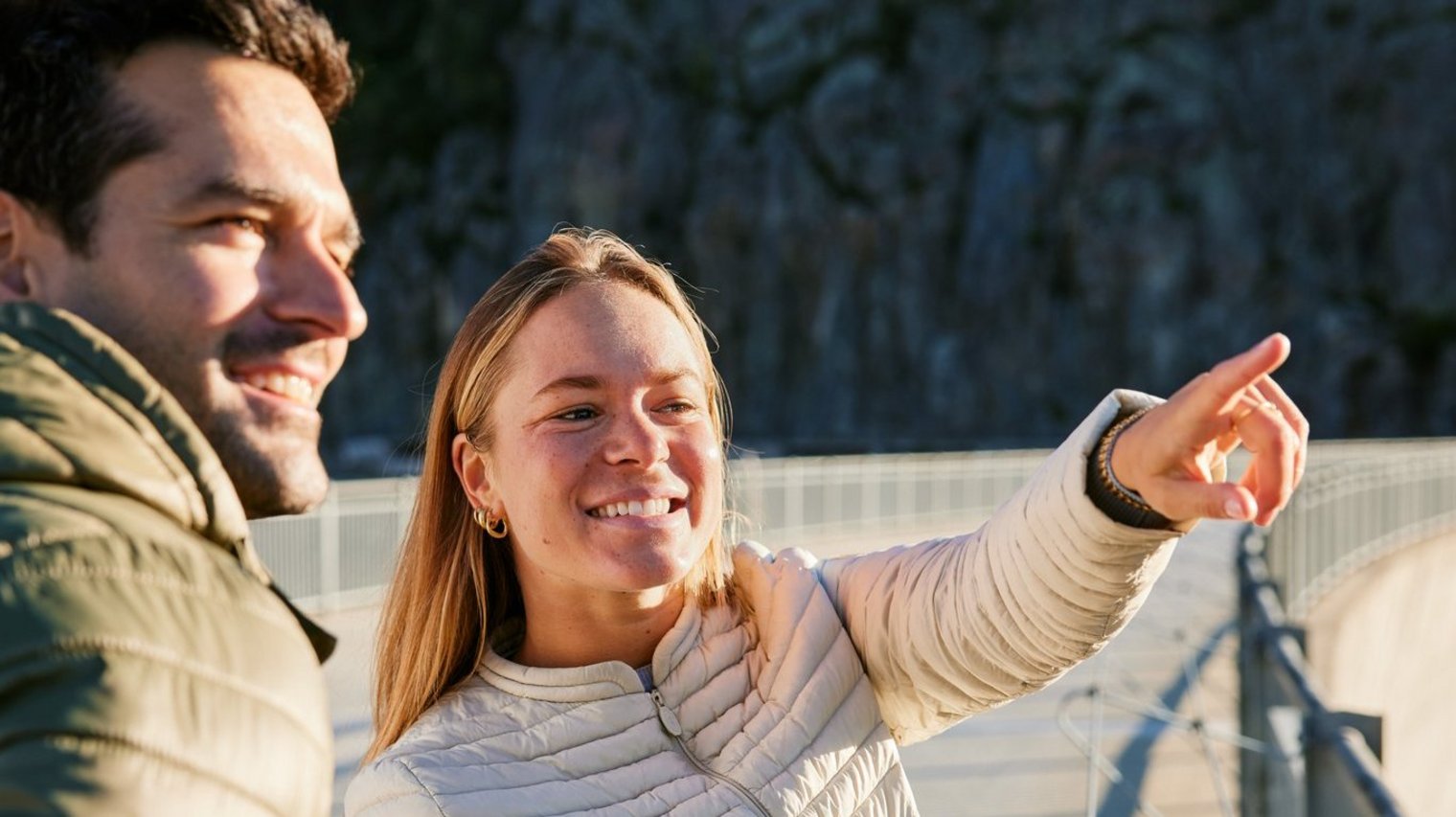 People pointing at something on dam