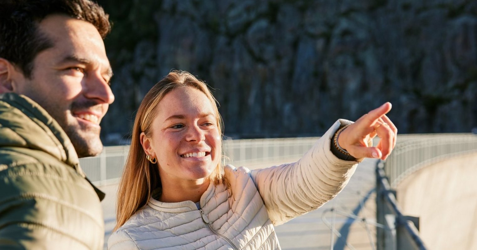 People pointing at something on dam