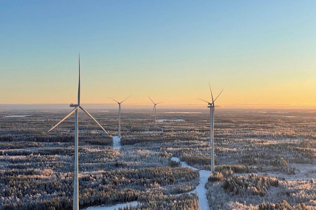 4 windturbines in the forest while sunset