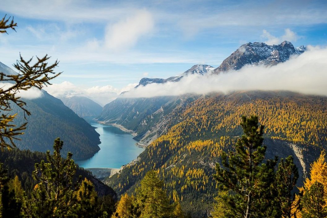 Ein weites Panorama mit einem Stausee und orangenen Bäumen